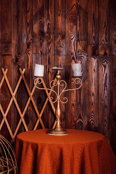 An old candlestick with candles on the table. Loft style in brown tones. High quality photo