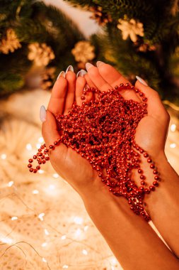 Noel kompozisyonu. Kırmızı boncuklu kadın elleri. Yüksek kalite fotoğraf