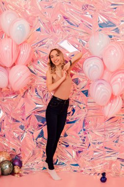 A young woman with balloons on a pink background. Holiday. High quality photo