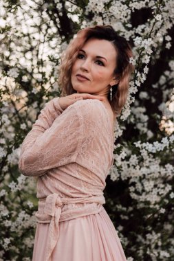 Bahar bahçesinde, kiraz çiçeklerinin yanında güzel bir kadın. Çiçek açan bahçe. Yüksek kalite fotoğraf