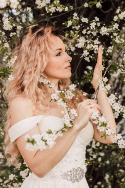 Bahar bahçesinde, kiraz çiçeklerinin yanında güzel bir kadın. Çiçek açan bahçe. Yüksek kalite fotoğraf