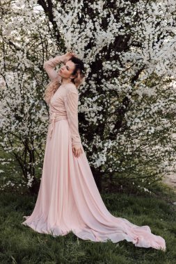 Bahar bahçesinde, kiraz çiçeklerinin yanında güzel bir kadın. Çiçek açan bahçe. Yüksek kalite fotoğraf