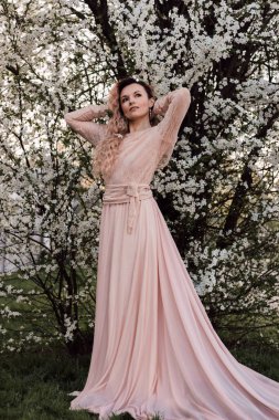 Bahar bahçesinde, kiraz çiçeklerinin yanında güzel bir kadın. Çiçek açan bahçe. Yüksek kalite fotoğraf