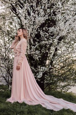 Bahar bahçesinde, kiraz çiçeklerinin yanında güzel bir kadın. Çiçek açan bahçe. Yüksek kalite fotoğraf