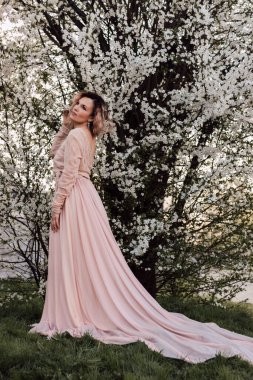 Bahar bahçesinde, kiraz çiçeklerinin yanında güzel bir kadın. Çiçek açan bahçe. Yüksek kalite fotoğraf