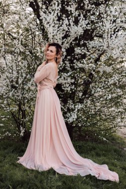 Bahar bahçesinde, kiraz çiçeklerinin yanında güzel bir kadın. Çiçek açan bahçe. Yüksek kalite fotoğraf