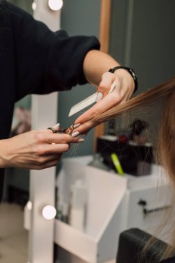 Güzellik salonunda bir kuaför, sarışının saçını kesiyor. Kadın tıraşı. Yüksek kalite fotoğraf