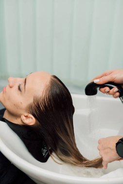 Bir kuaför bir güzellik salonunda sarı saçlarını yıkar. Saç bakımı ve tedavi. Yüksek kalite fotoğraf