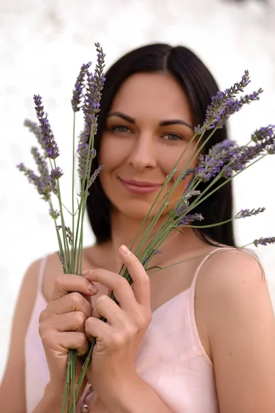 Woman with a bouquet of lavender on a white background. Aromatherapy with herbs from the garden. High quality photo