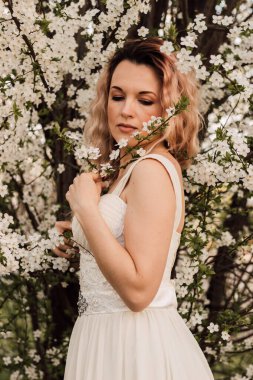 Kiraz çiçeklerinin yanında çekici bir kadın. Bahar Çiçeği Bahçesi. Yüksek kalite fotoğraf