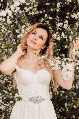 Bir kız baharda çiçek açan bir ağacın yanında duruyor. Kiraz çiçekleri. Yüksek kalite fotoğraf