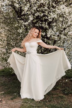 Bir kız baharda çiçek açan bir ağacın yanında duruyor. Kiraz çiçekleri. Yüksek kalite fotoğraf