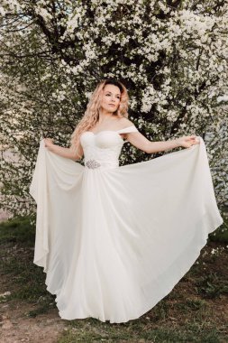 Bir kız baharda çiçek açan bir ağacın yanında duruyor. Kiraz çiçekleri. Yüksek kalite fotoğraf