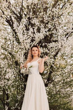 Kiraz çiçeklerinin yanında çekici bir kadın. Bahar Çiçeği Bahçesi. Yüksek kalite fotoğraf