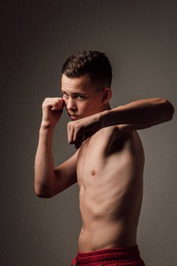 Genç bir boksör, karanlık arka planda boks eğitimi alıyor. Agresif bir spor. Yüksek kalite fotoğraf