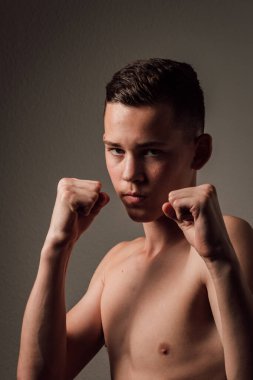 Genç bir boksör, karanlık arka planda boks eğitimi alıyor. Agresif bir spor. Yüksek kalite fotoğraf