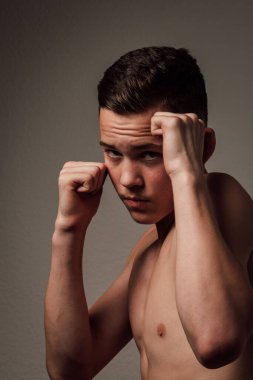 Genç bir boksör, karanlık arka planda boks eğitimi alıyor. Agresif bir spor. Yüksek kalite fotoğraf