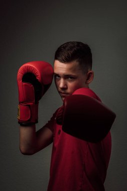 Genç bir boksör, karanlık arka planda boks eğitimi alıyor. Agresif bir spor. Yüksek kalite fotoğraf