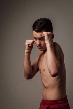 Genç bir boksör, karanlık arka planda boks eğitimi alıyor. Agresif bir spor. Yüksek kalite fotoğraf