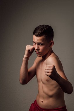 Genç bir boksör, karanlık arka planda boks eğitimi alıyor. Agresif bir spor. Yüksek kalite fotoğraf