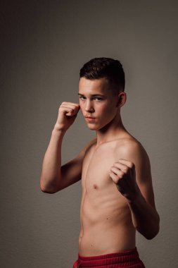 Genç bir boksör, karanlık arka planda boks eğitimi alıyor. Agresif bir spor. Yüksek kalite fotoğraf