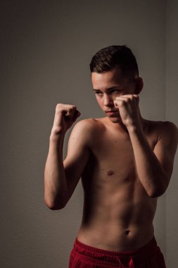 Genç bir boksör, karanlık arka planda boks eğitimi alıyor. Agresif bir spor. Yüksek kalite fotoğraf