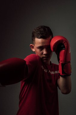 Genç bir boksör, karanlık arka planda boks eğitimi alıyor. Agresif bir spor. Yüksek kalite fotoğraf