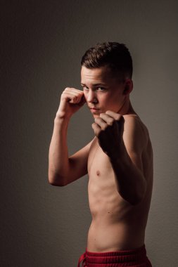 Genç bir boksör, karanlık arka planda boks eğitimi alıyor. Agresif bir spor. Yüksek kalite fotoğraf