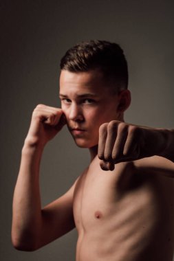 Genç bir boksör, karanlık arka planda boks eğitimi alıyor. Agresif bir spor. Yüksek kalite fotoğraf