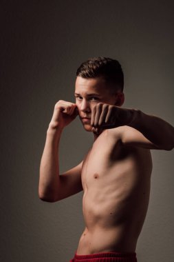Genç bir boksör, karanlık arka planda boks eğitimi alıyor. Agresif bir spor. Yüksek kalite fotoğraf