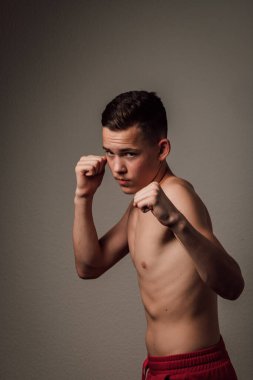 Genç bir boksör, karanlık arka planda boks eğitimi alıyor. Agresif bir spor. Yüksek kalite fotoğraf