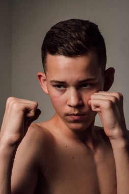 Genç bir boksör, karanlık arka planda boks eğitimi alıyor. Agresif bir spor. Yüksek kalite fotoğraf