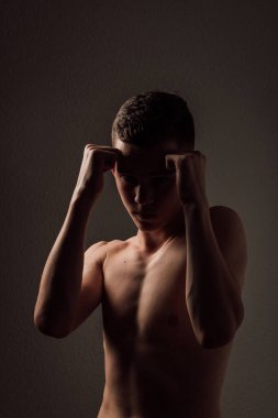 Genç bir boksör, karanlık arka planda boks eğitimi alıyor. Agresif bir spor. Yüksek kalite fotoğraf