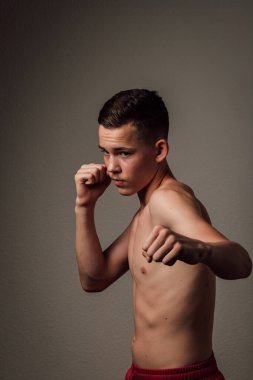 Genç bir boksör, karanlık arka planda boks eğitimi alıyor. Agresif bir spor. Yüksek kalite fotoğraf