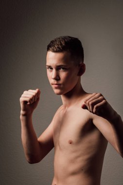 Genç bir boksör, karanlık arka planda boks eğitimi alıyor. Agresif bir spor. Yüksek kalite fotoğraf