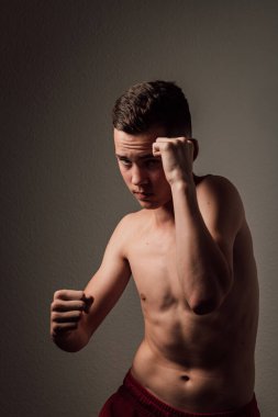 Genç bir boksör, karanlık arka planda boks eğitimi alıyor. Agresif bir spor. Yüksek kalite fotoğraf