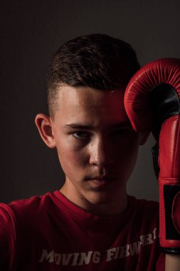 Genç bir boksör, karanlık arka planda boks eğitimi alıyor. Agresif bir spor. Yüksek kalite fotoğraf