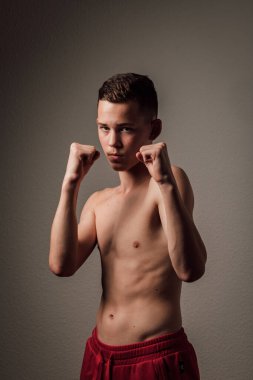 Genç bir boksör, karanlık arka planda boks eğitimi alıyor. Agresif bir spor. Yüksek kalite fotoğraf