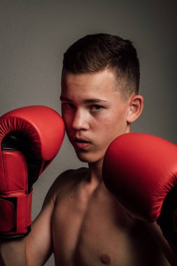 Genç bir boksör, karanlık arka planda boks eğitimi alıyor. Agresif bir spor. Yüksek kalite fotoğraf