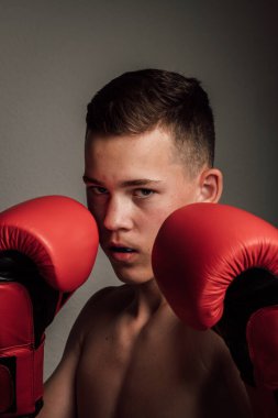 Genç bir boksör, karanlık arka planda boks eğitimi alıyor. Agresif bir spor. Yüksek kalite fotoğraf