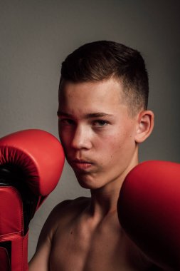 Genç bir boksör, karanlık arka planda boks eğitimi alıyor. Agresif bir spor. Yüksek kalite fotoğraf