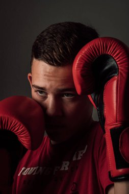 Genç bir boksör, karanlık arka planda boks eğitimi alıyor. Agresif bir spor. Yüksek kalite fotoğraf