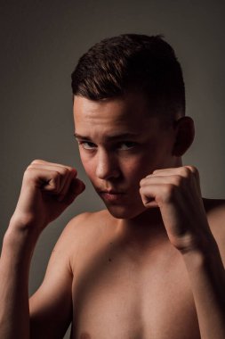 Genç bir boksör, karanlık arka planda boks eğitimi alıyor. Agresif bir spor. Yüksek kalite fotoğraf