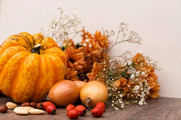Herbstliche Komposition Auf Dem Tisch Stehen Kürbisse Zwiebeln Nüsse Hagebutten — Stockfoto
