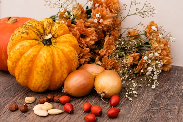 Herbstliche Komposition Auf Dem Tisch Stehen Kürbisse Zwiebeln Nüsse Hagebutten — Stockfoto