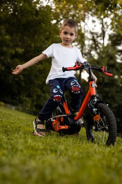 Bir çocuk gölün yakınındaki bir parkta bisiklet sürüyor. Liseli çocuğun izin günü. Yüksek kalite fotoğraf