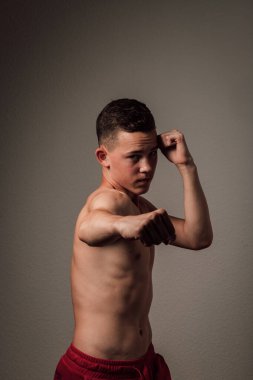 Genç bir boksör, karanlık arka planda boks eğitimi alıyor. Agresif bir spor. Yüksek kalite fotoğraf