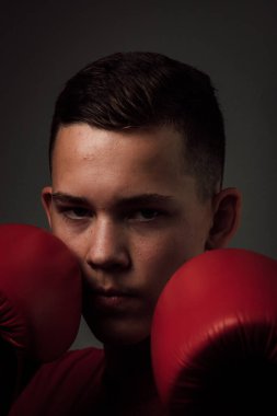 Genç bir boksör, karanlık arka planda boks eğitimi alıyor. Agresif bir spor. Yüksek kalite fotoğraf