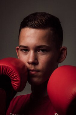 Genç bir boksör, karanlık arka planda boks eğitimi alıyor. Agresif bir spor. Yüksek kalite fotoğraf