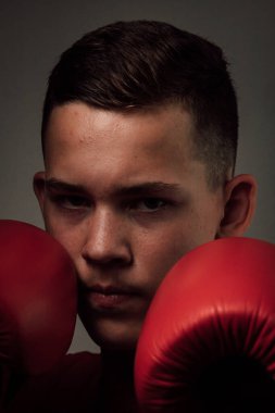 Genç bir boksör, karanlık arka planda boks eğitimi alıyor. Agresif bir spor. Yüksek kalite fotoğraf